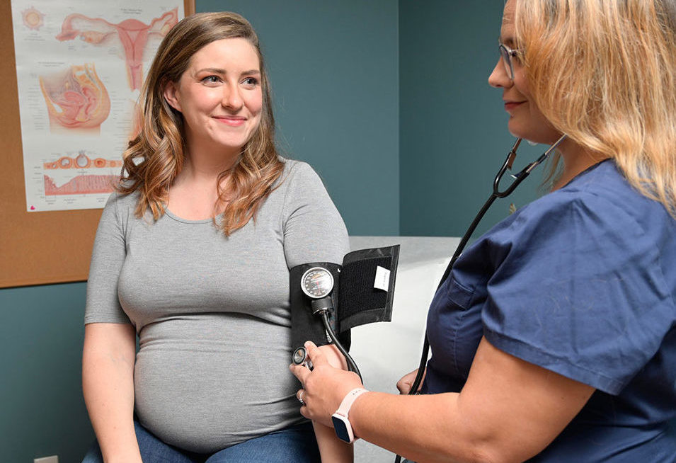 Healthcare Professional Taking a Pregnant Woman's Blood Pressure at CODAC.