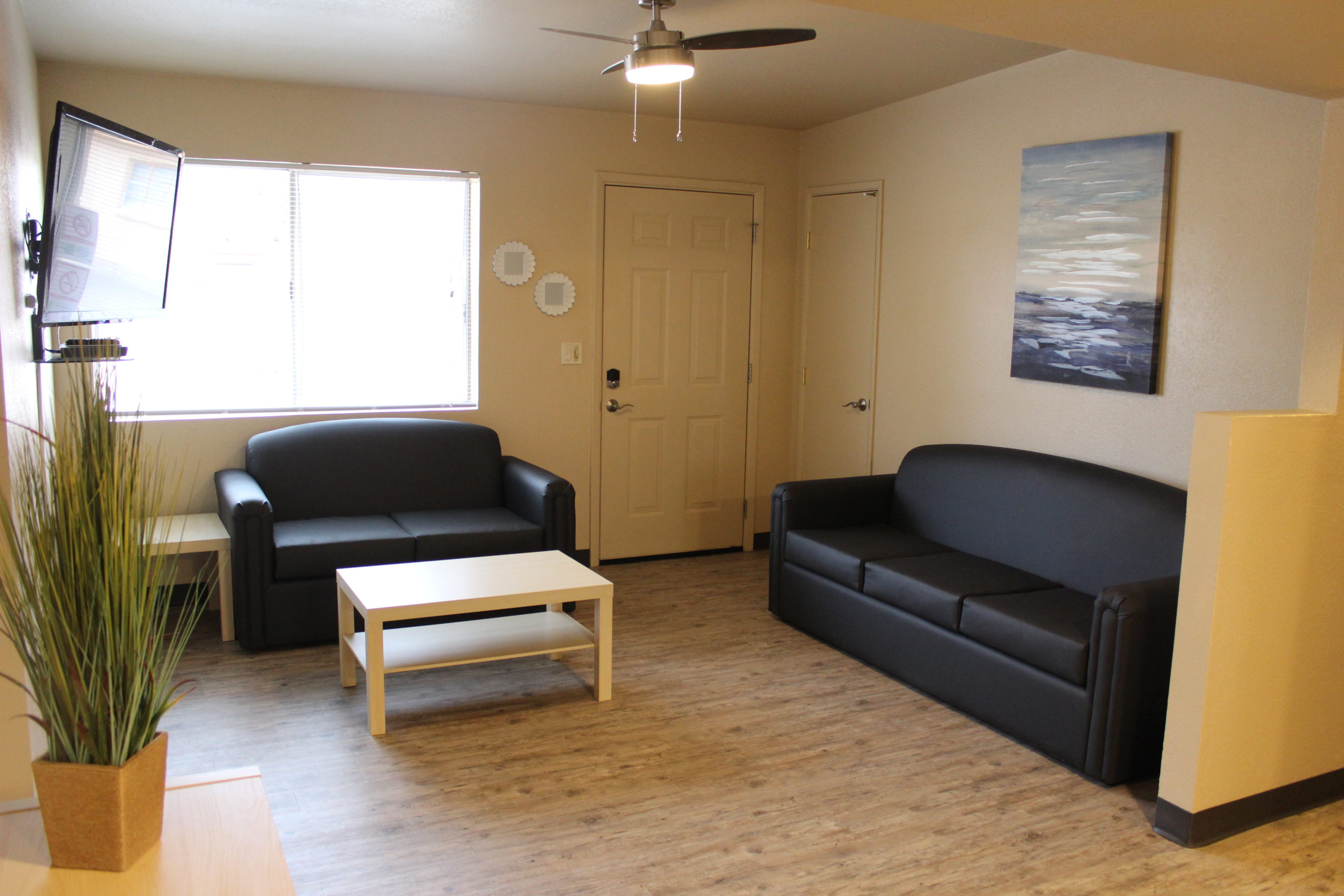 A Living Room With a Couch and a Table at a CODAC Residential Treatment Gila House.