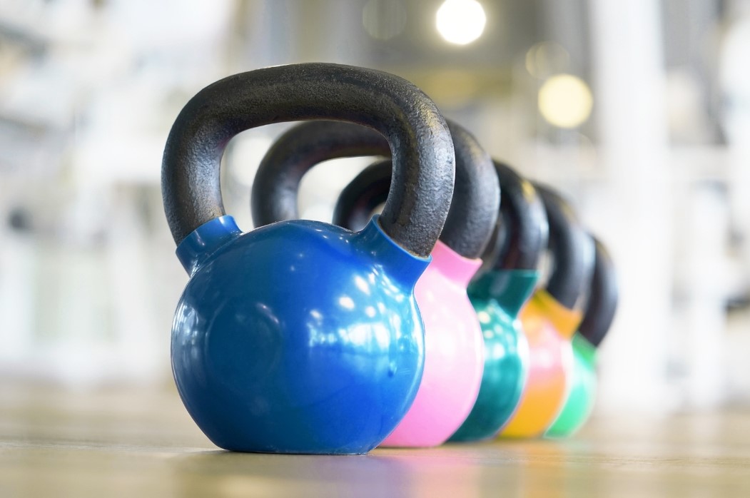 5 Colorful Dumbbells in a Row Set on the Floor for Personal Training.